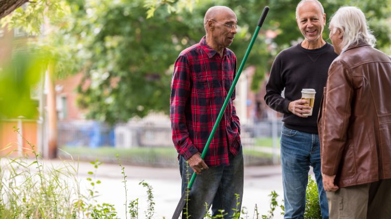 Senior neighbours chatting to one another in the street
