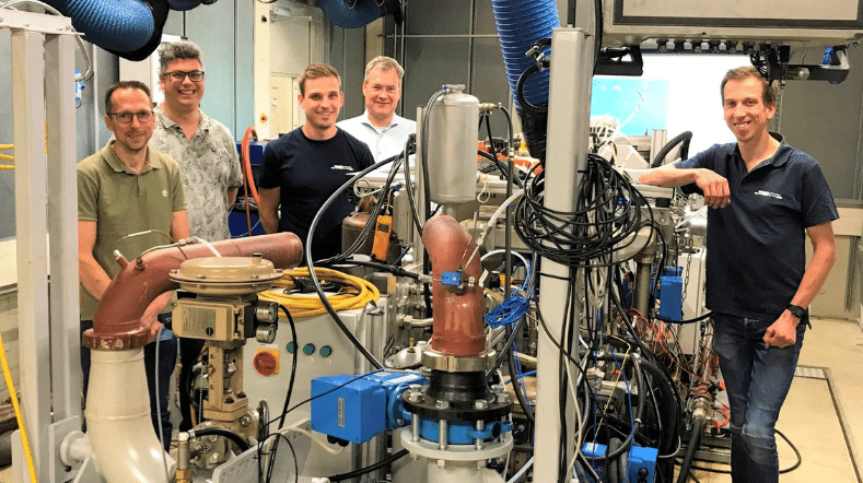 TNO experts pose in front of hydrogen combustion engine